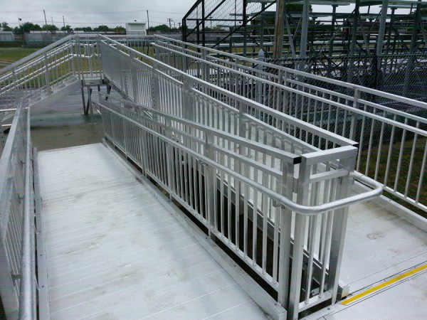 a commercial wheelchair ramp in concrete with metal railings