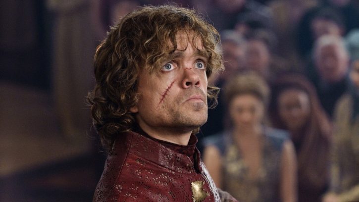 PeterDinklage in a scene from Game of Thrones as Tyrion Lannister looks off camera, a frown on his face, as well as a long scar, diagonal on his cheek.